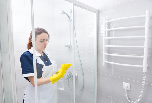 Maid or housekeeper cleaning a bathroom