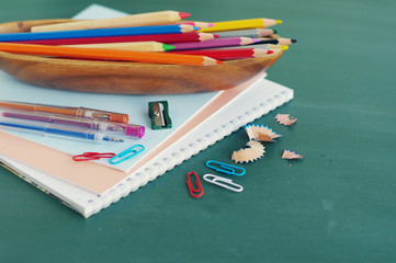 School supplies against a green board.