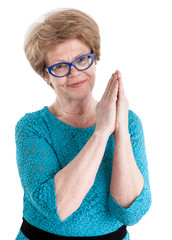 Portrait of joyful European woman of retirement age with folded hands, isolated on white background