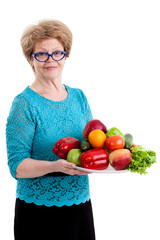 Fototapeta na wymiar An elderly woman holding a tray with fruits and vegetables in hands, isolated white background