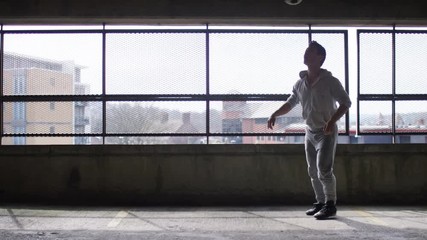 Wide shot of football player doing tricks with a soccer ball in urban city environment