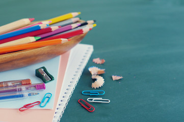 School supplies against a green board.