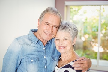 Portrait of happy senior couple embracing at home