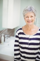 Portrait of senior woman standing in bathroom