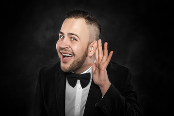 Man listening something over dark background.