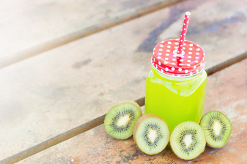 Kiwi juice and kiwi clices on a wooden table