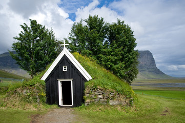 Fototapeta na wymiar Old small wooden church of Nupstadur with grass on the roof, Iceland