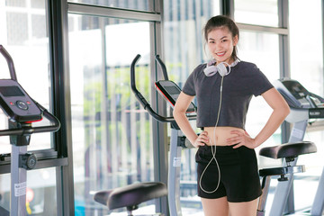 Fototapeta na wymiar Asian beautiful girls wearing headphone in fitness center with t