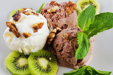 Chocolate and  vanilla ice cream with kiwi and mint on a plate