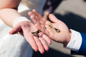 Obraz na płótnie Canvas Wedding key in hand, the bride and groom hold the key