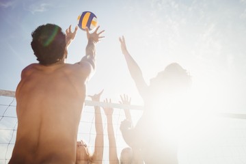 Friends playing beach volleyball