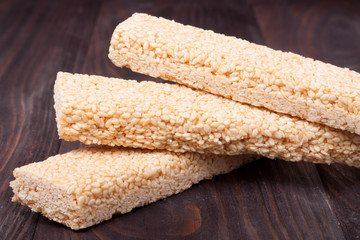 Honey bars with sesame seeds on wooden background
