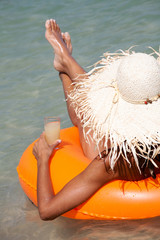 femme assise dans une bouée gonflable en maillot dans l'eau