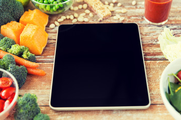 close up of blank tablet pc screen and vegetables