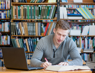 Student with laptop studying in the university library