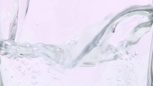 pouring water into a beaker on a white background