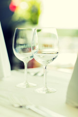 close up of two wine glasses on restaurant table