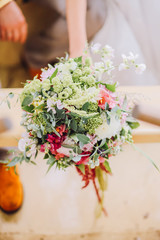 Bride holding wedding bouquet of various flowers