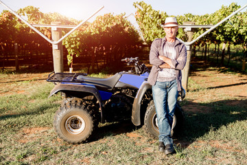 Obraz premium Man standing next to truck in vineyard