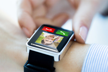 close up of hands with incoming call on smartwatch