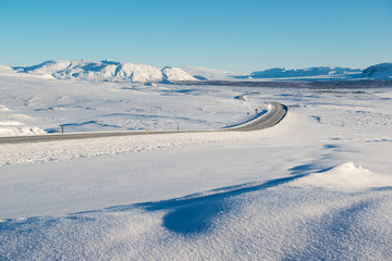 Winter landscape, empty road surrounded by snow capped mountains, Iceland