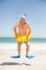 Senior man with swimming ring and flippers jumping