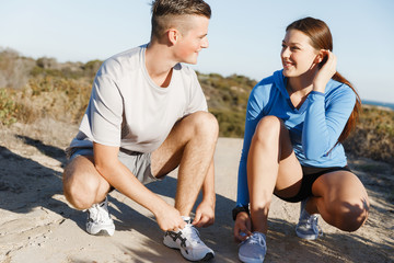 Couple of runners lace their shoes and prepare to jogging