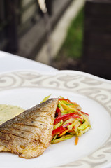 delicious fish with vegetables served on white plate