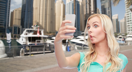 funny young woman taking selfie with smartphone