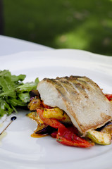 delicious fish with vegetables served on white plate