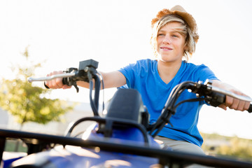 Boy riding farm truck in vineyard