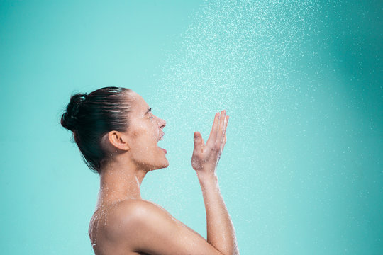 Woman enjoying water in the shower under a jet