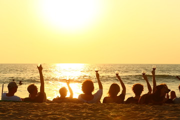 joy/ friends sitting on the beach to see a sunset