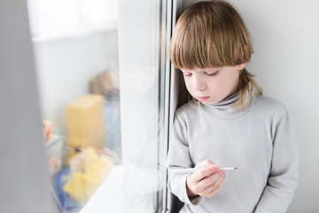 Child boy thermometer measures temperature.