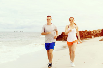 Fototapeta premium Runners. Young couple running on beach