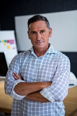 Portrait of confident man standing with arms crossed