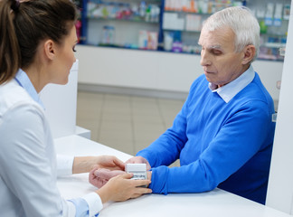 Beautiful young woman pharmacist measuring blood pressure to sen © Nejron Photo