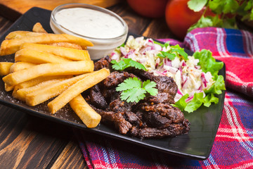 Kebab of beef with french fries and salad