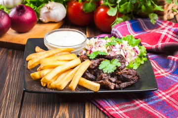 Kebab of beef with french fries and salad