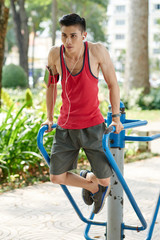 Young Asian man performing exercise for his arms