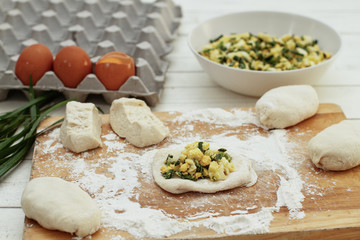 Preparing for the Russian pies, filling of the room (eggs and green onions) in the test of yeast. Pies - the traditional fried rolls stuffed with a set of fillings.
