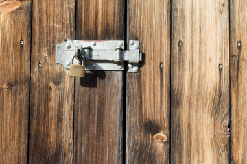 old wooden door with padlock,  metal latch