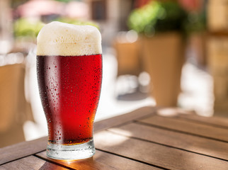 Glass of light beer on the wooden table.