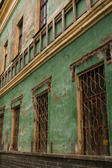 Fototapeta na wymiar Old green shabby wall of an abandoned building