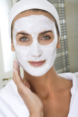 femme se faisant un masque de beauté dans sa salle de bain