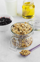 Breakfast: granola, yogurt, honey, blueberry on a white backgrou