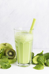 Ingredients for smoothie: spinach, kiwi, apple, celery on a whit