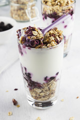 Useful dessert of granola, yogurt and blueberry in glass on a wh