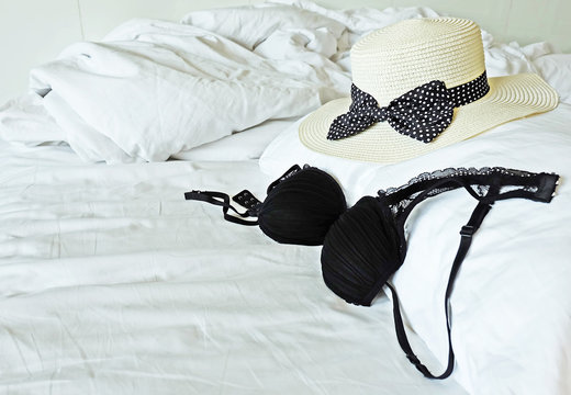 Lingerie over messy bed.
