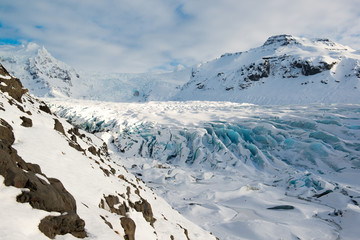 Langue du glacier Svinafellsjokull en hiver, fissures de glace bleue couvertes de neige, Islande